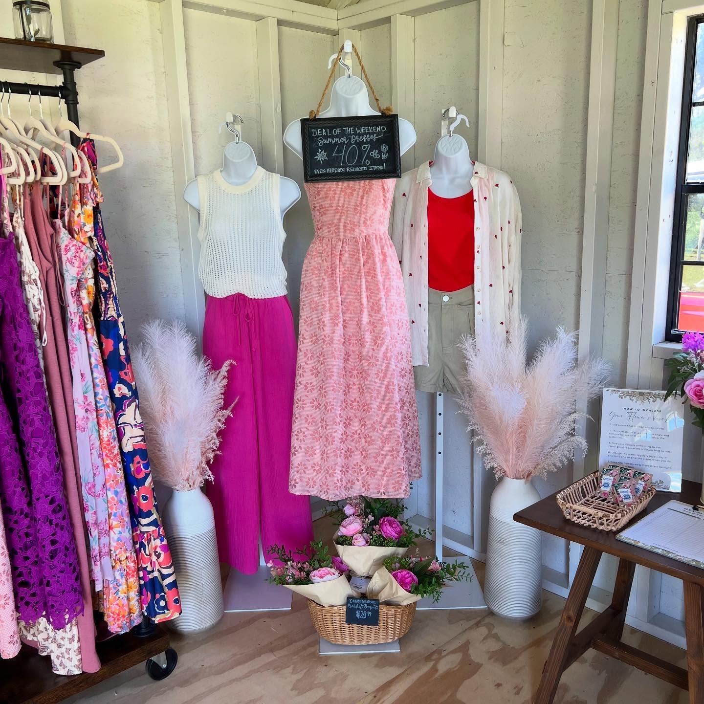 Display of women's boutique clothing including dresses and tops in the Branch and Bloom Farms Farmstand