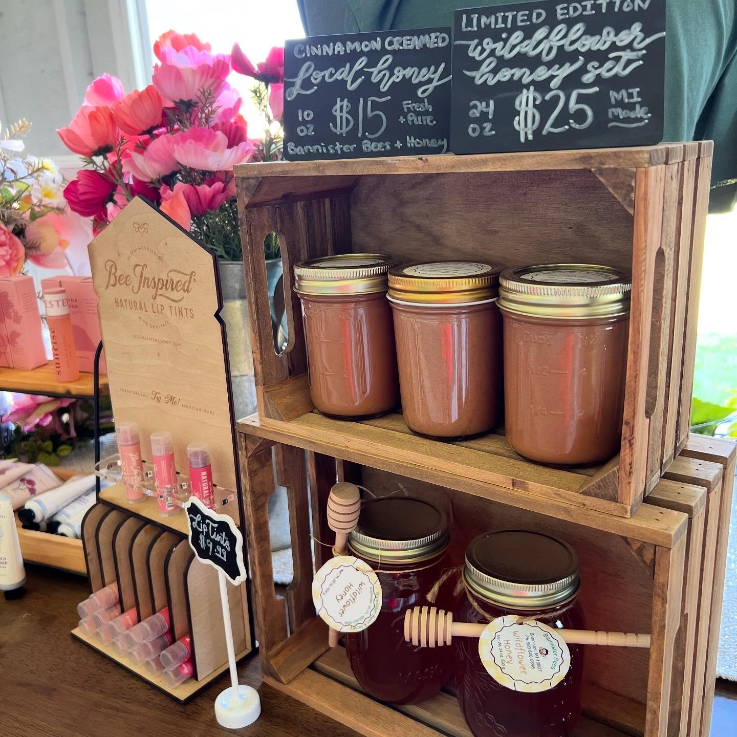 Wooden crate with jars of honey and a sign in a store setting
