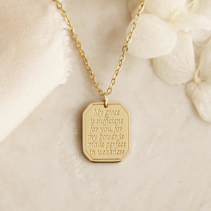 Gold Christian necklace with an engraved pendant that says "My grace is sufficient for you, for my power is made perfect in weakness"
