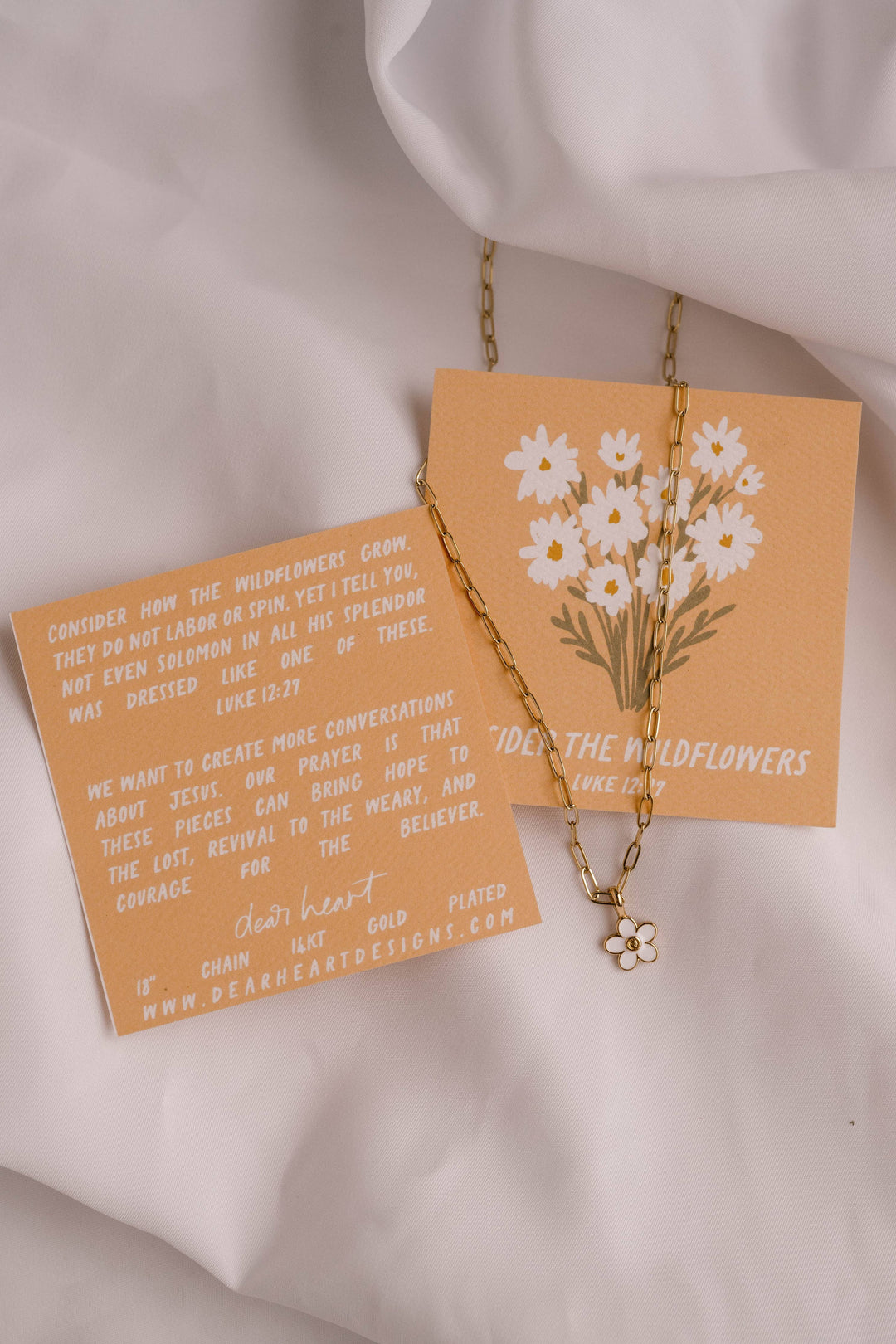 Necklace with floral pendant on a matching card against a white background