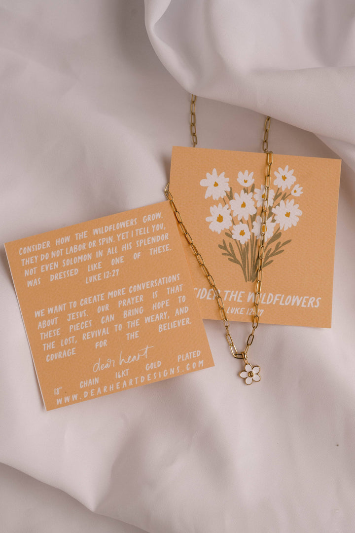 Necklace with floral pendant on a matching card against a white background