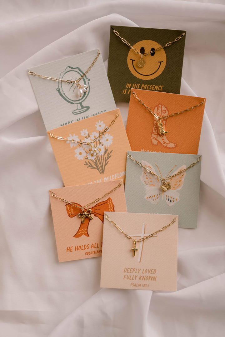 Collection of necklaces on display with matching cards featuring designs and text.