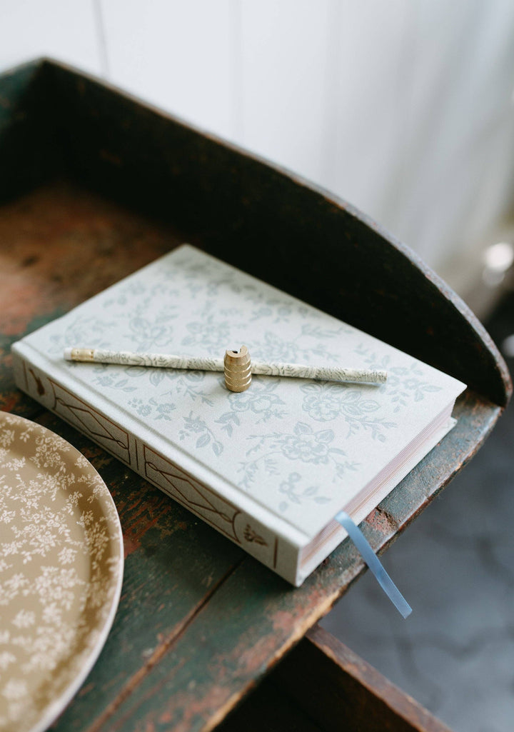 Open book with a pen on top, placed on a wooden surface.