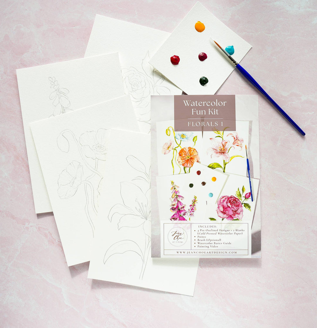Watercolor Fun Kit with floral designs, paintbrushes, and watercolor stones on a pink background