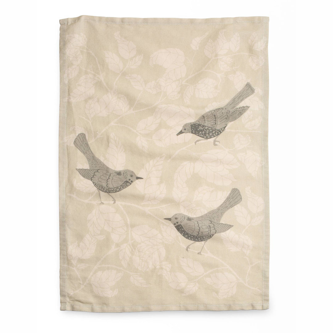 Beige fabric linen tea towel with bird patterns on a white background