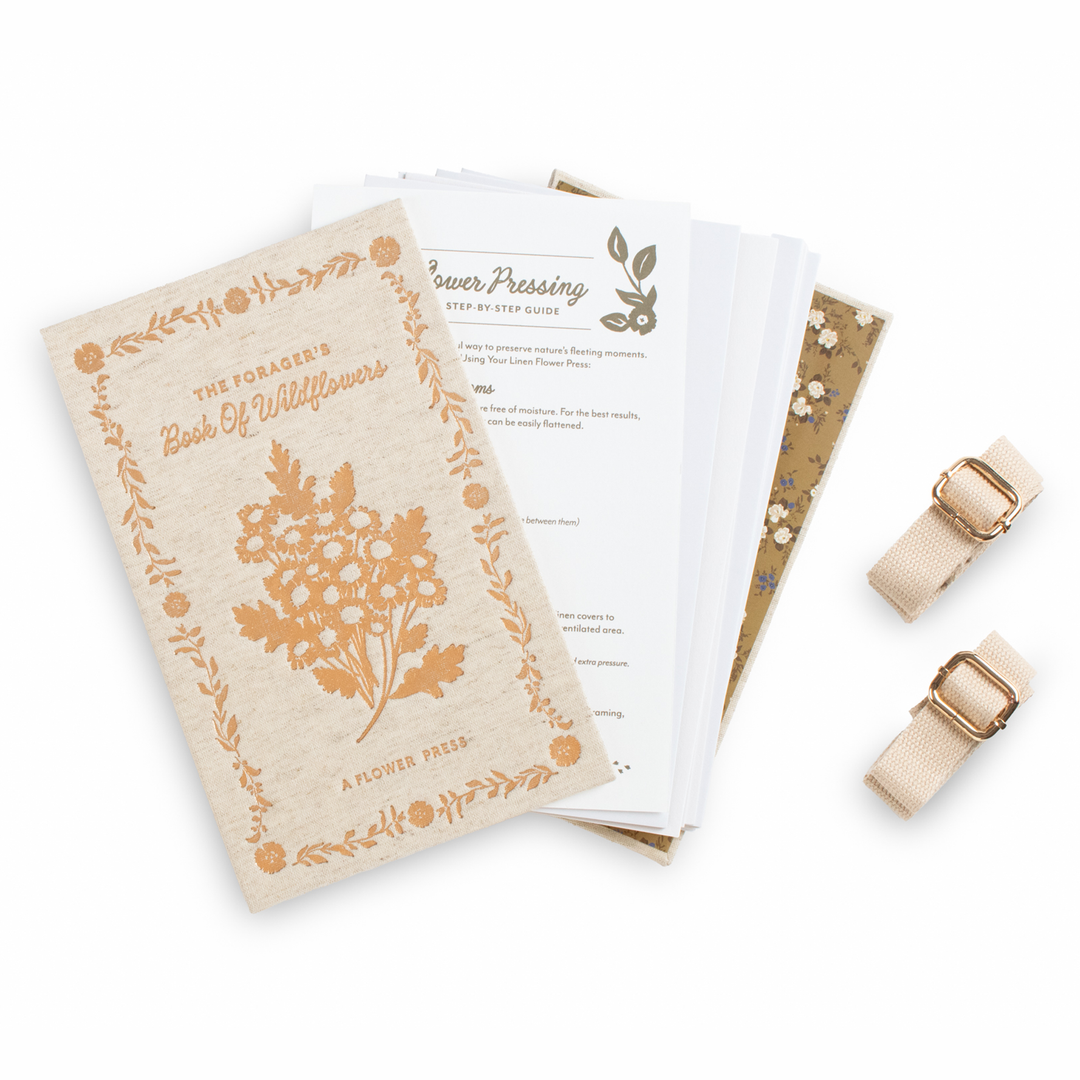 Flower pressing kit with a book and tools on a white background