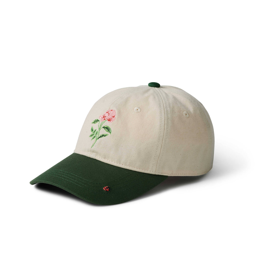 Beige baseball cap with embroidered rose and ladybug design on a white background