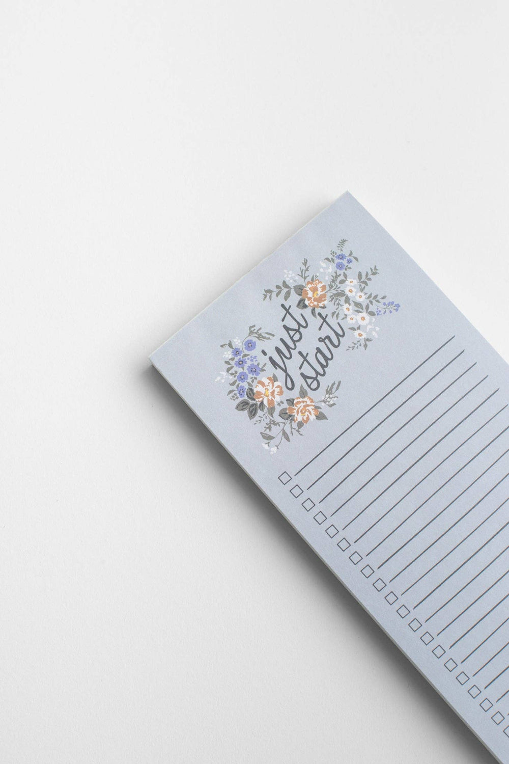 Notepad with floral design and text on a light gray background