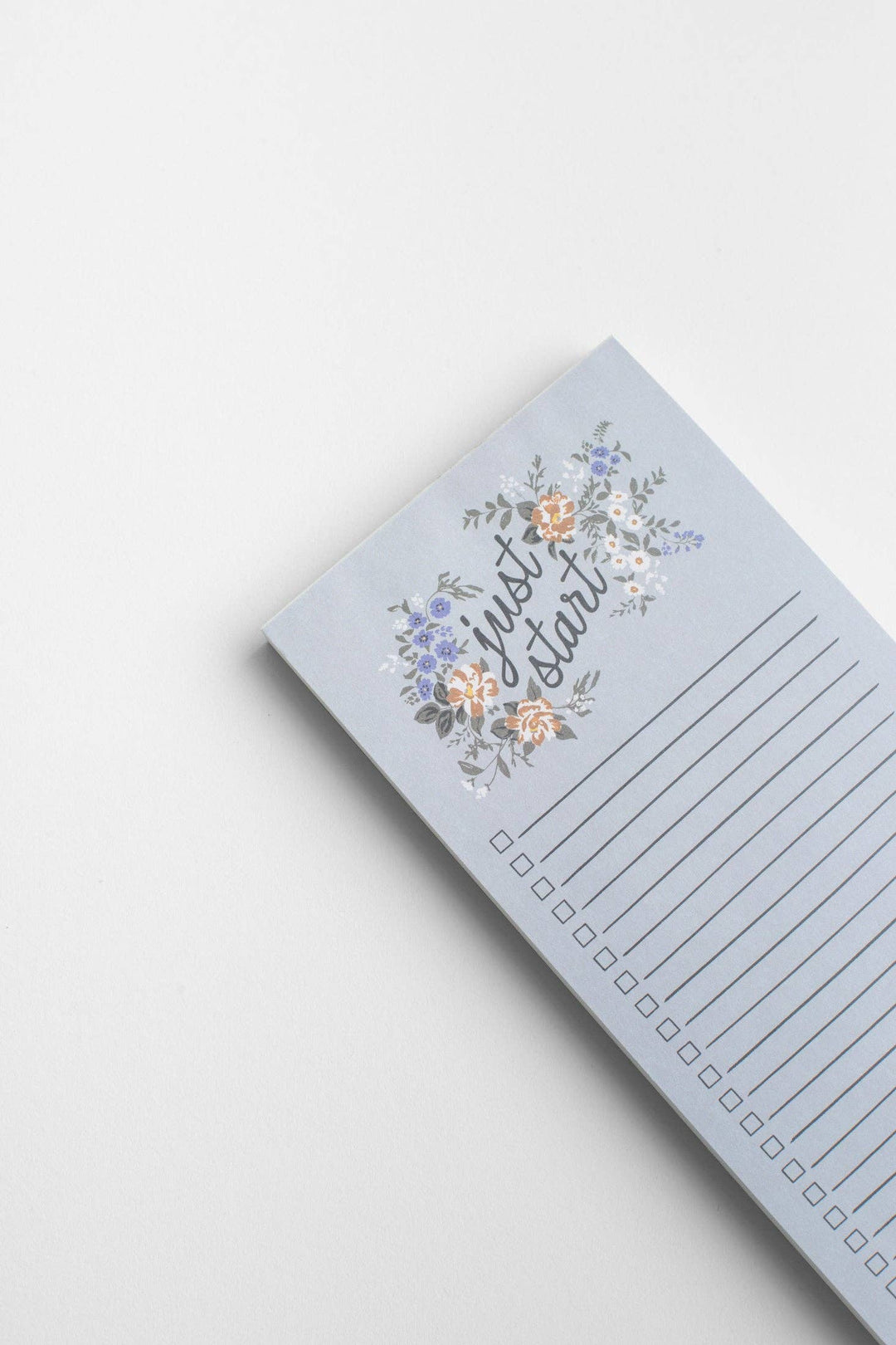 Notepad with floral design and text on a light gray background