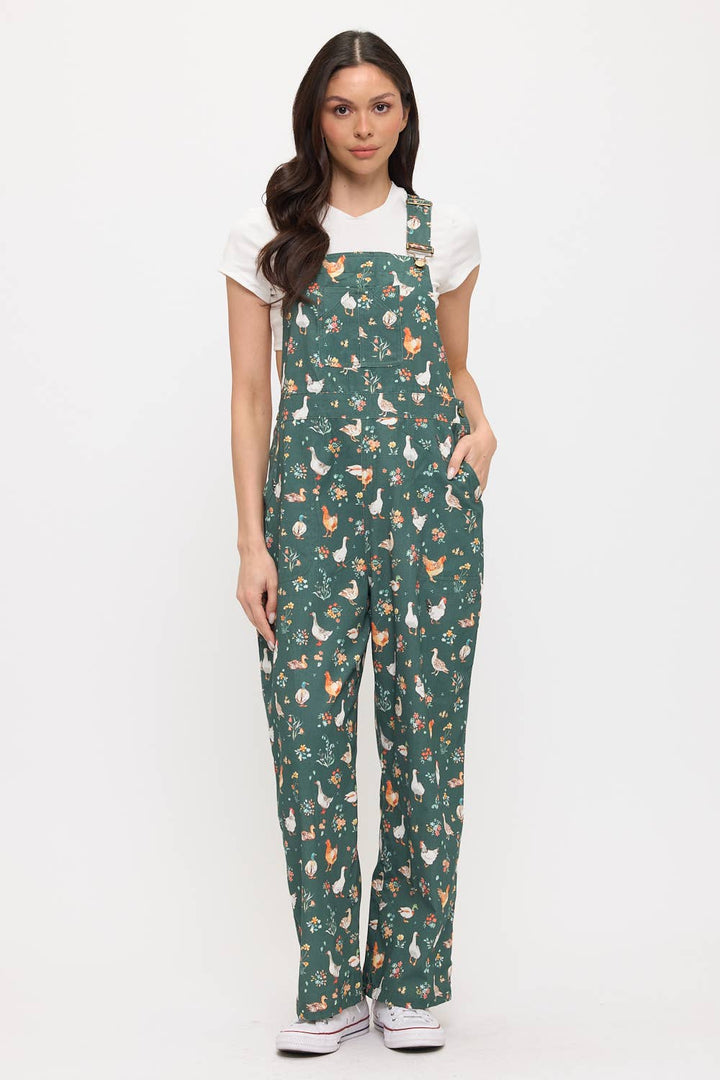 Woman wearing a green patterned overalls with ducks and chickens on a white background