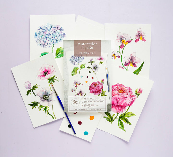 Floral watercolor art set with paintbrushes on a light purple background