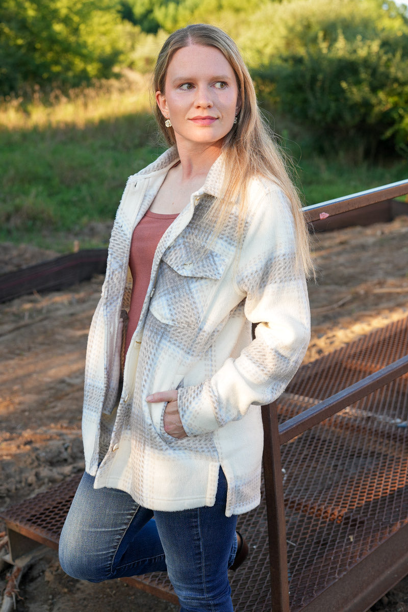 Woman wearing a plaid fleece jacket in an outdoor setting