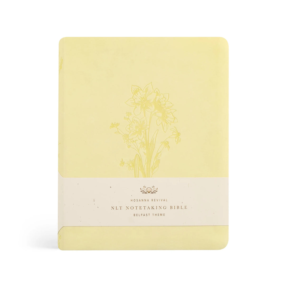 Yellow Bible with floral design and scripture on a white background