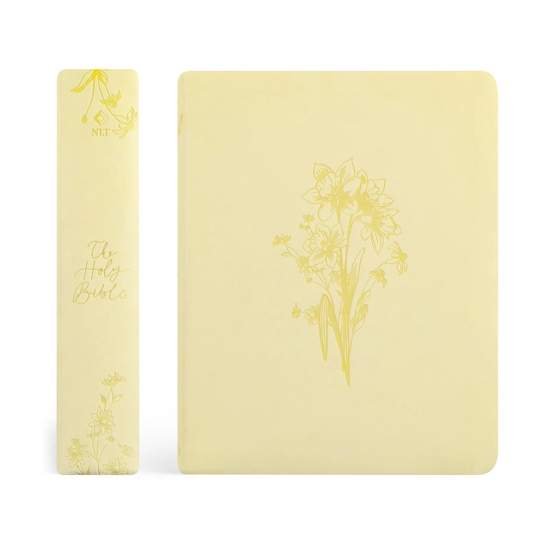 Two yellow Bibles with floral designs on a white background