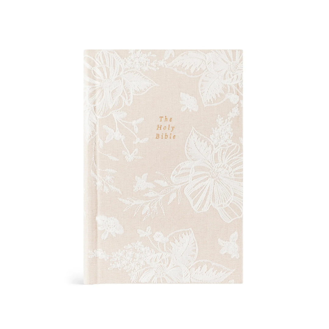 Beige Bible cover with white embroidered floral patterns on a white background