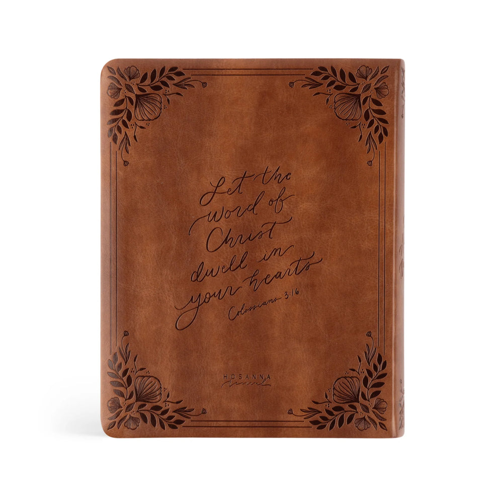 Brown leather Bible with engraved verse on a white background