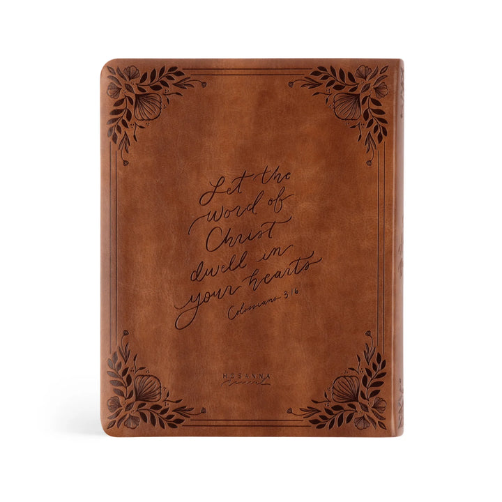 Brown leather Bible with engraved verse on a white background