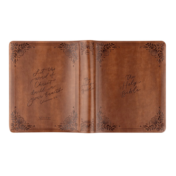 Brown leather-bound Bible with engraved text and designs on a white background