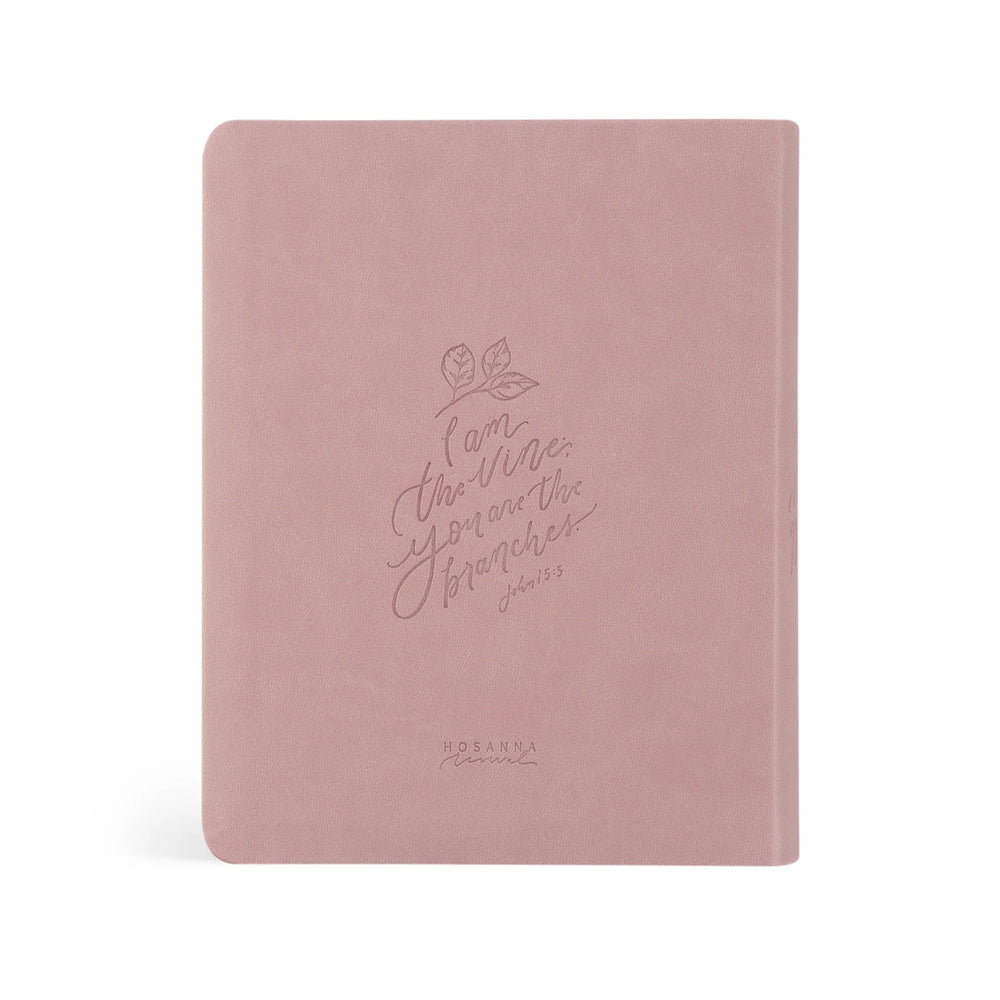 Pink Bible with embossed text on a white background