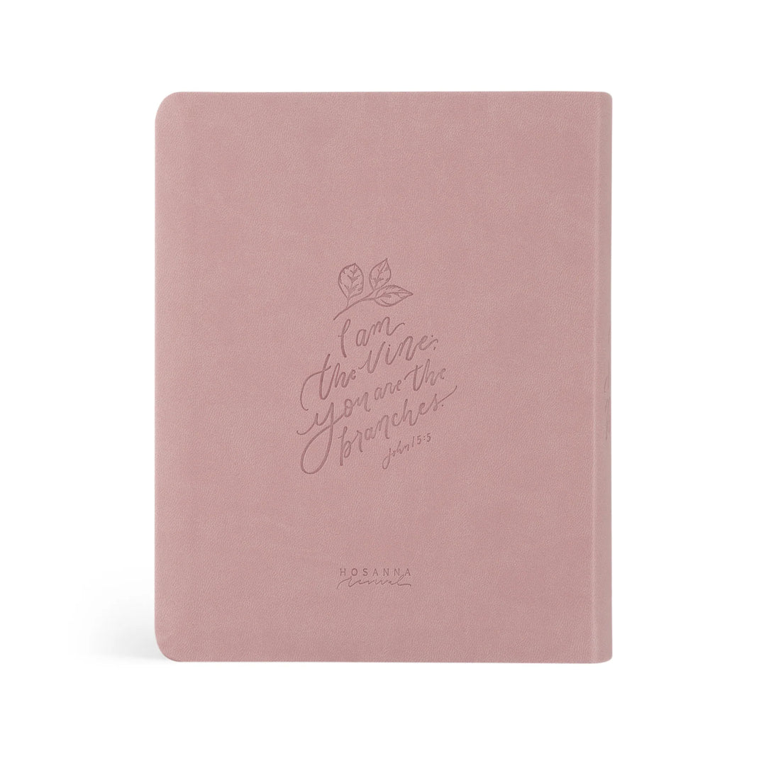 Pink Bible with embossed text on a white background