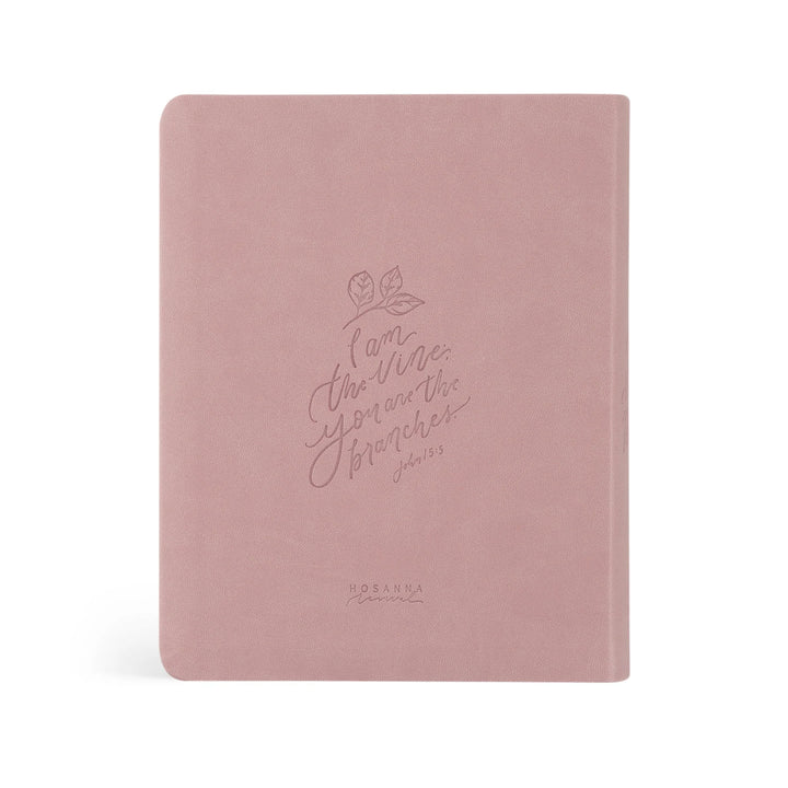 Pink Bible with embossed text on a white background