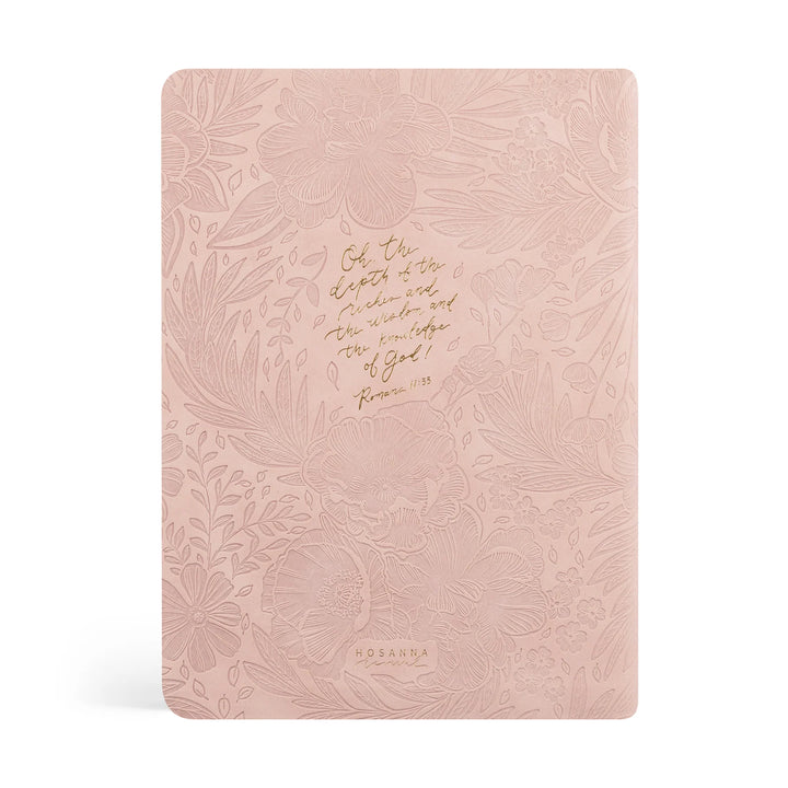 Pink Bible with floral embossing and gold scripture text on a white background