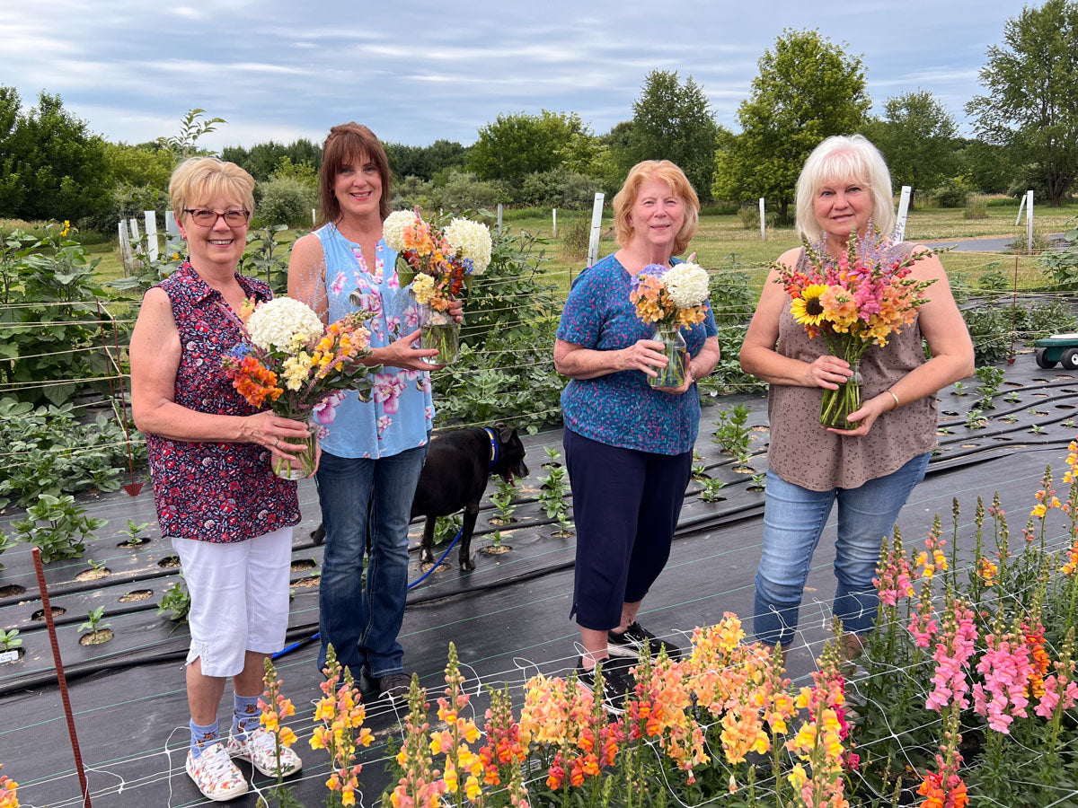 Four women holding bouquets of flowers at a Branch and Bloom Farms floral workshop