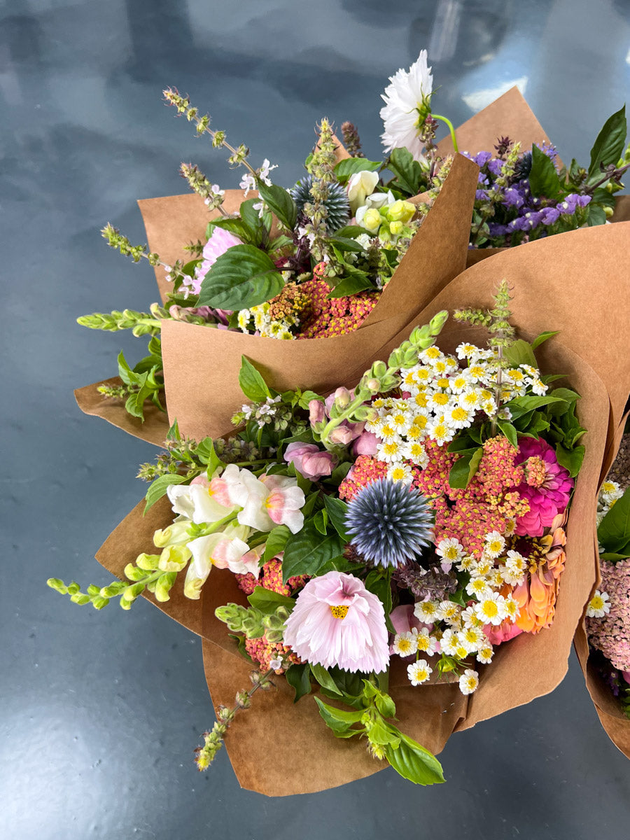 Market Bouquet of colorful local flowers wrapped in brown kraft paper