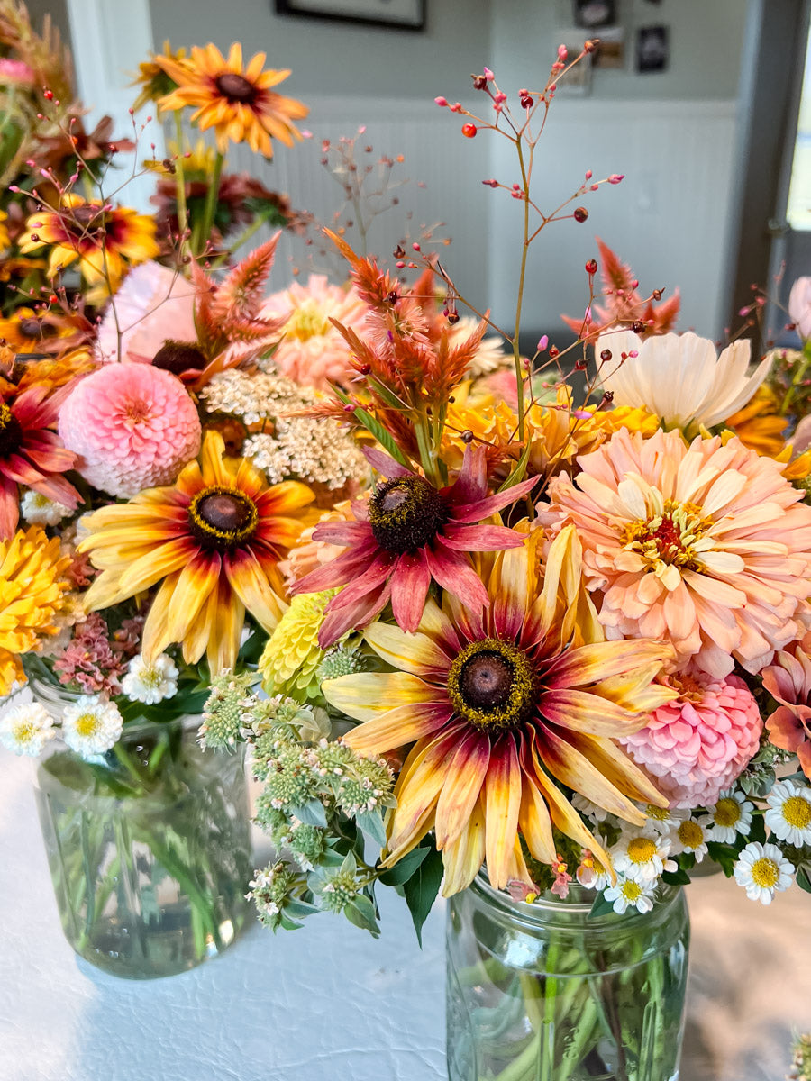 Colorful custom mason jar arrangements featuring a palette of pink, yellow and peach