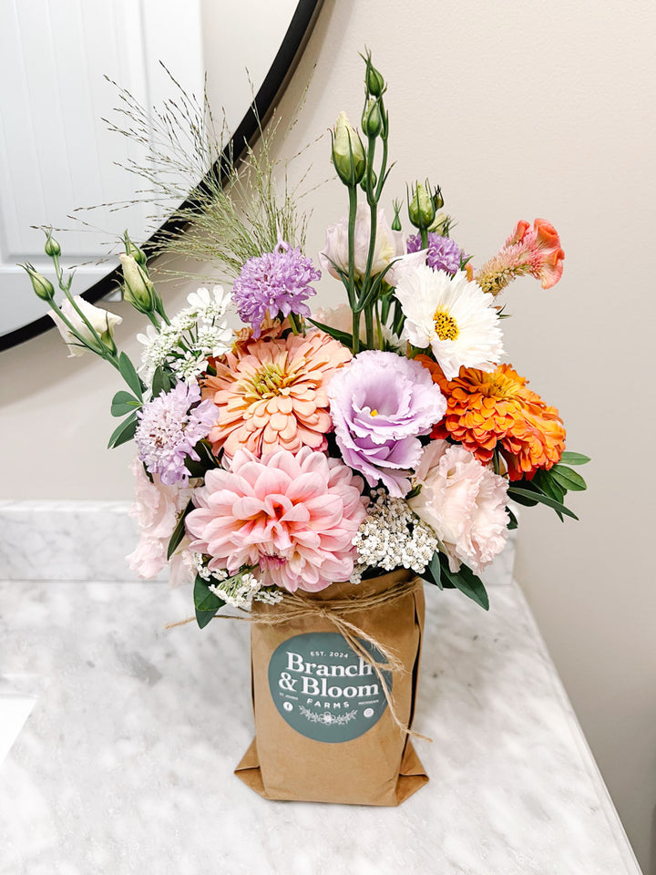 Custom mason jar arrangement featuring a palette of lavender, pink and peach flowers