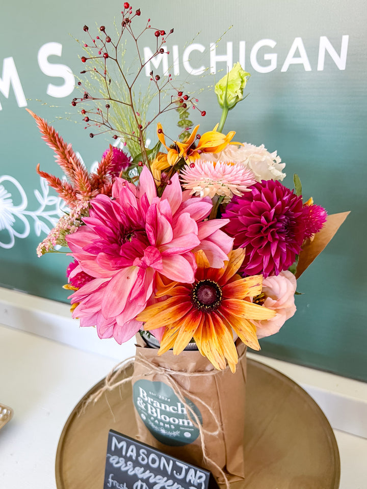 Colorful flower arrangement in a mason jar with 'Michigan' text in the background