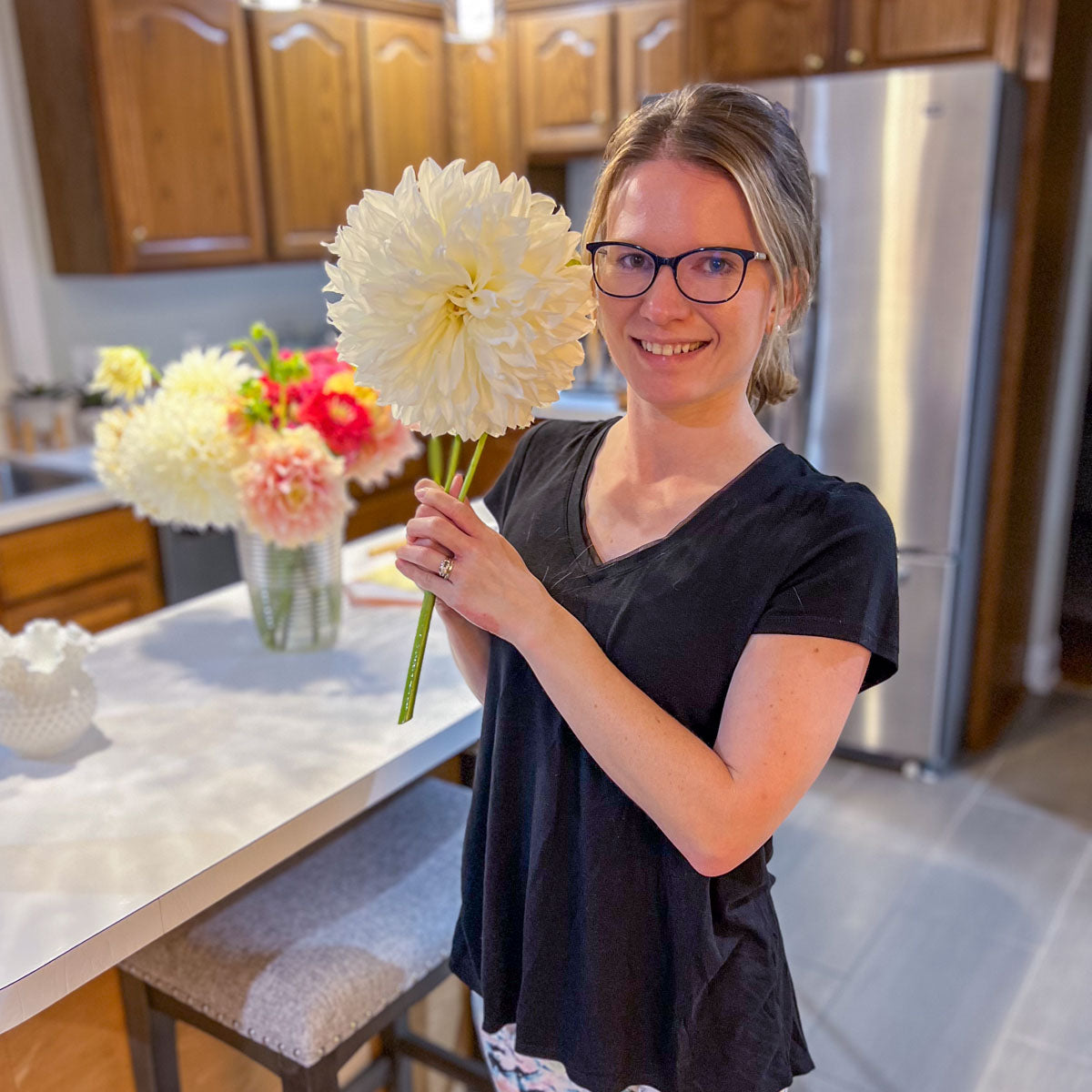 Emily Miller of Branch and Bloom Farms holding a white dinnerplate dahlia