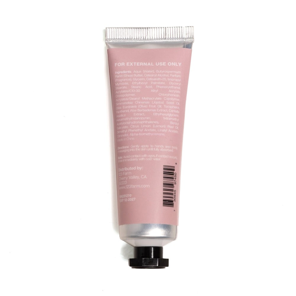 Pink tube of hand cream with silver cap on a white background