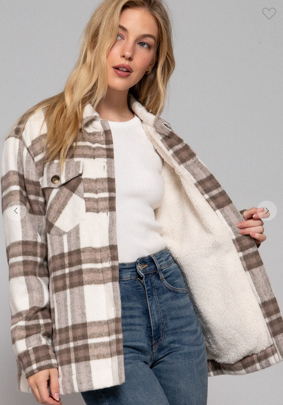 Woman wearing a plaid coat with a white shirt and jeans on a gray background