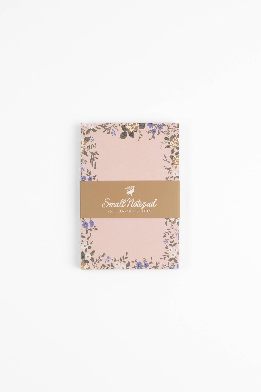 Small pink notebook with floral design and gold label on a white background
