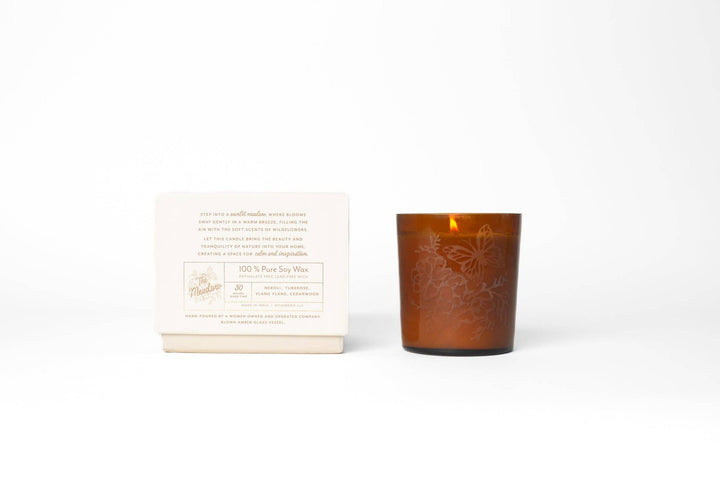 Brown glass candle with a white label on a white background