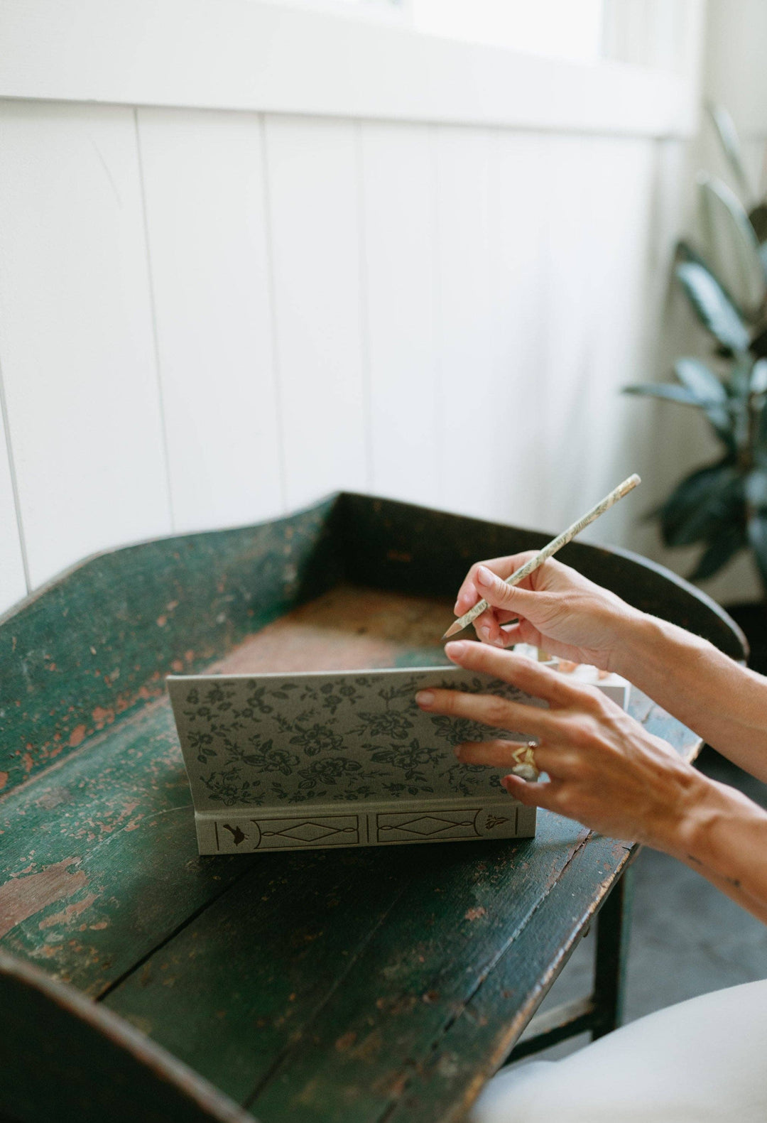 Person holding a matchbox and matchstick on a rustic wooden surface