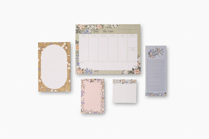 Set of floral-themed notepads and stationery on a white background