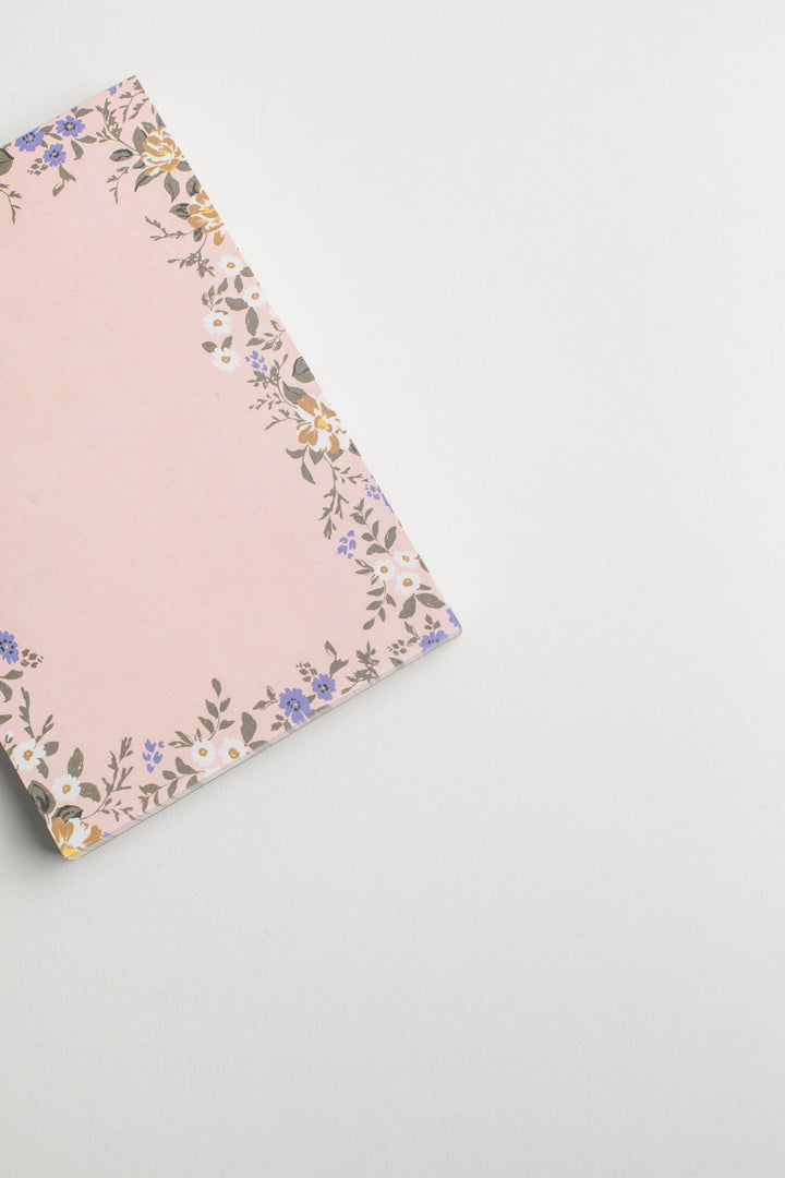 Pink notebook with florals on a neutral background